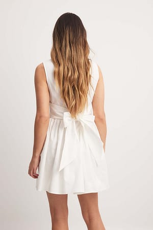 White Miniklänning med rosettdetalj och djup rygg