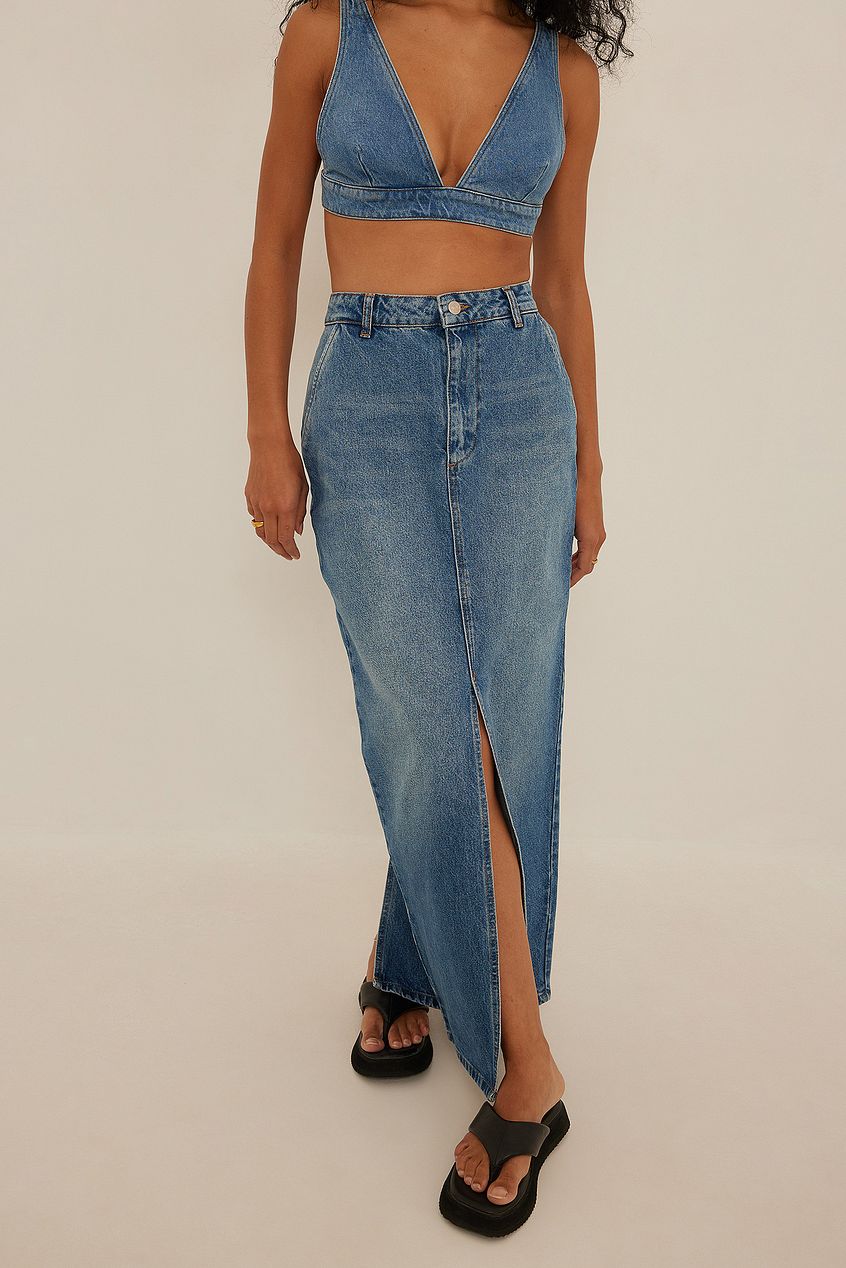 This on trend for 2022 denim maxi skirt from NA-KD features a high waist, a zip and button closure, side pockets, a front slit, a back slit detail and denim material. This maxi skirt comes in blue.