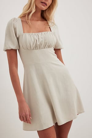 Beige Mini-jurk met pofmouwen en gestrikte achterkant
